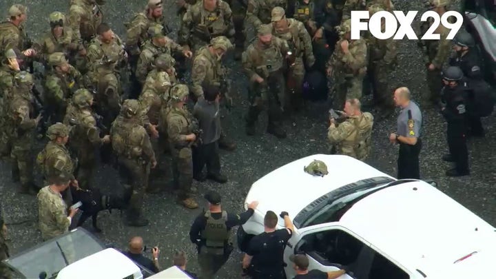 Law enforcement pose for a photo after capturing Danelo Cavalcante