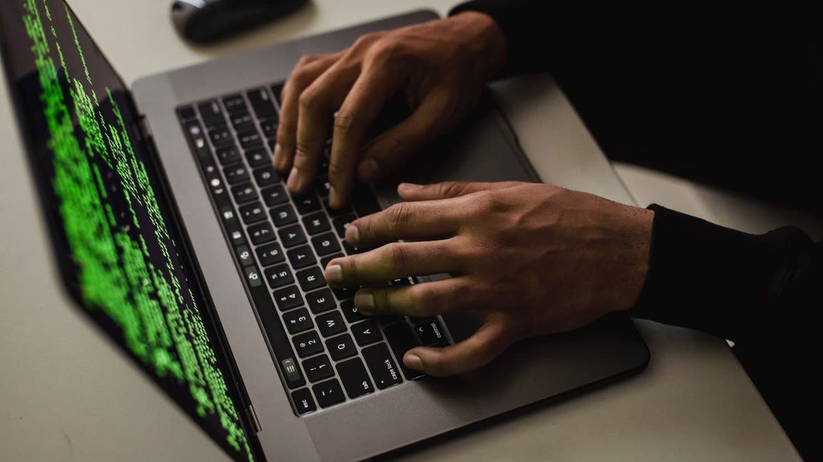 Hacker typing on their laptop.