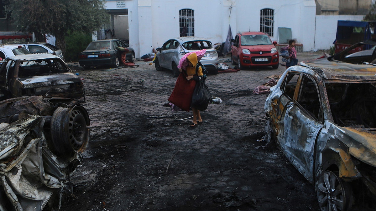 Palestinians carry belongings leave al-Ahli hospital