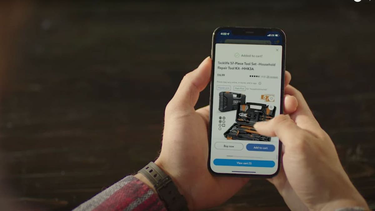 Person holding up their phone and shopping on the Walmart app.