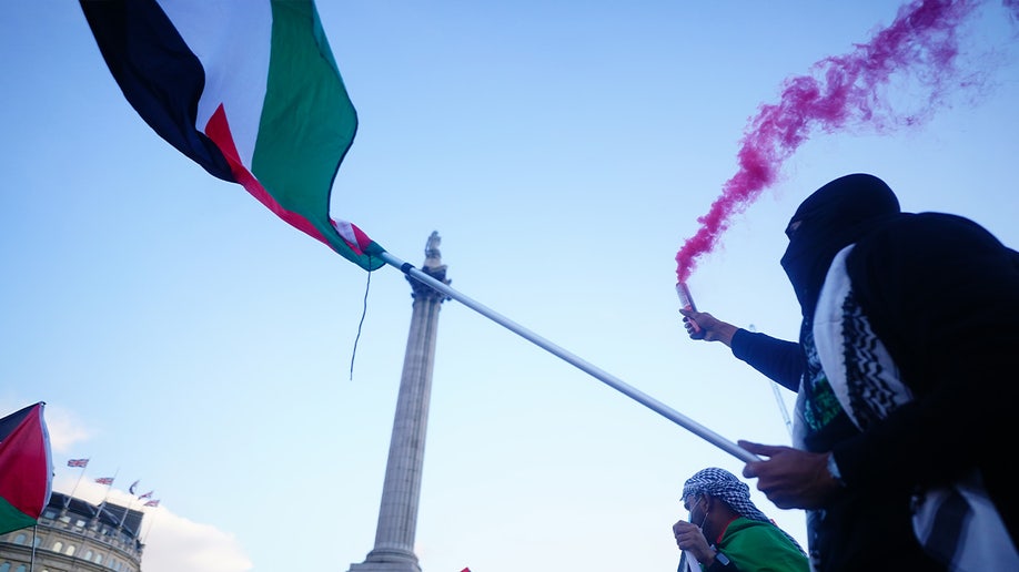 Man hold Palestinian flag at rally in London
