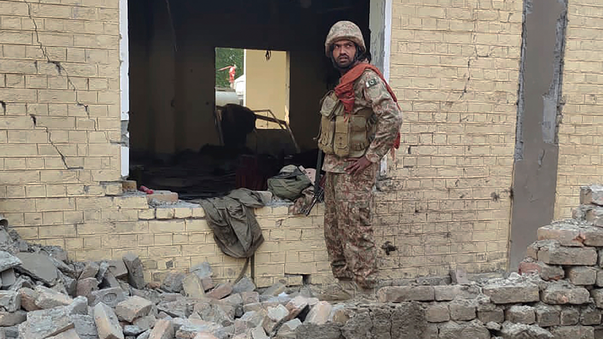 Army soldier examines damages at bombing site