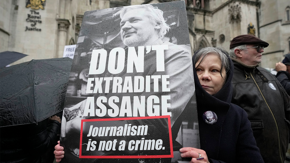 A protester holds a placard outside the Royal Courts of Justice in London