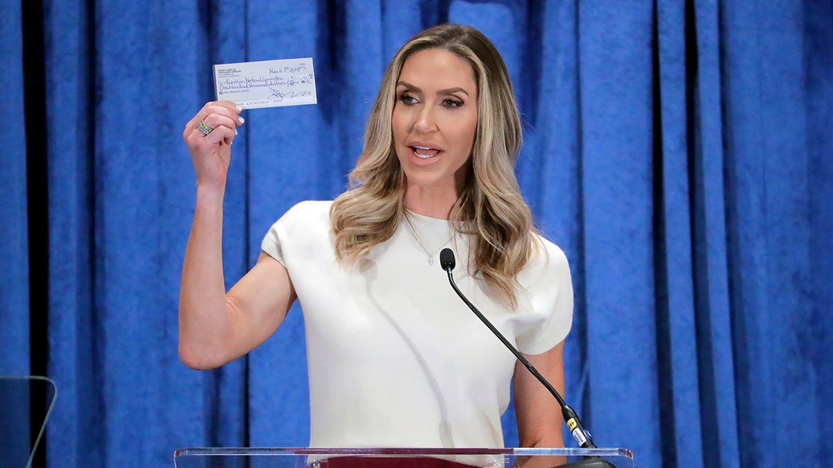 Lara Trump holds up RNC donation check