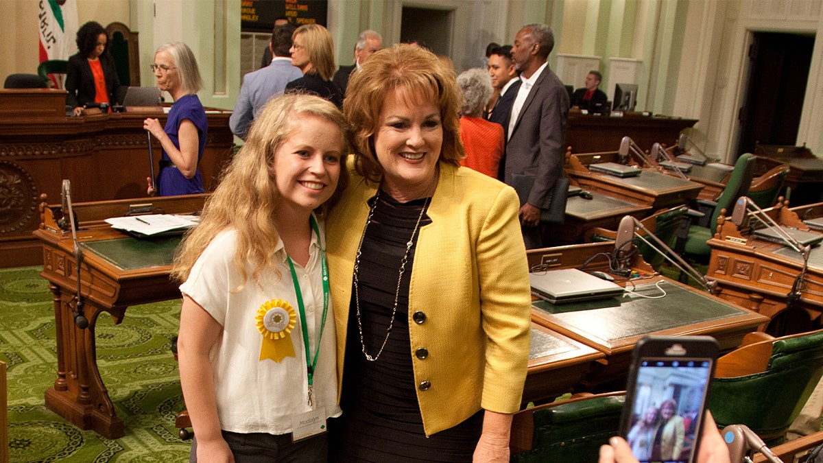 California State Sen. Sharon Grove poses with girl for picture on chamber floor