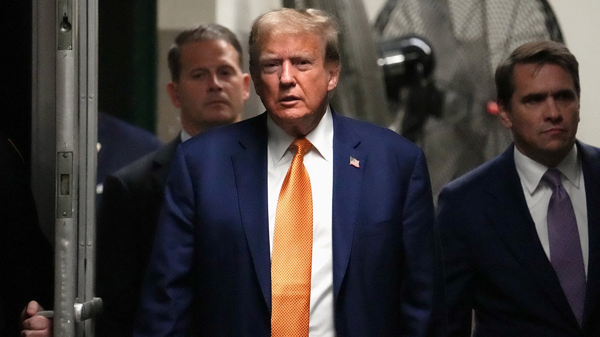 Donald Trump walks through the courtroom hallway.