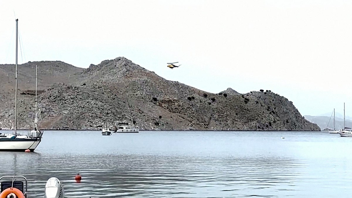 A helicopter flies over the island of Symi