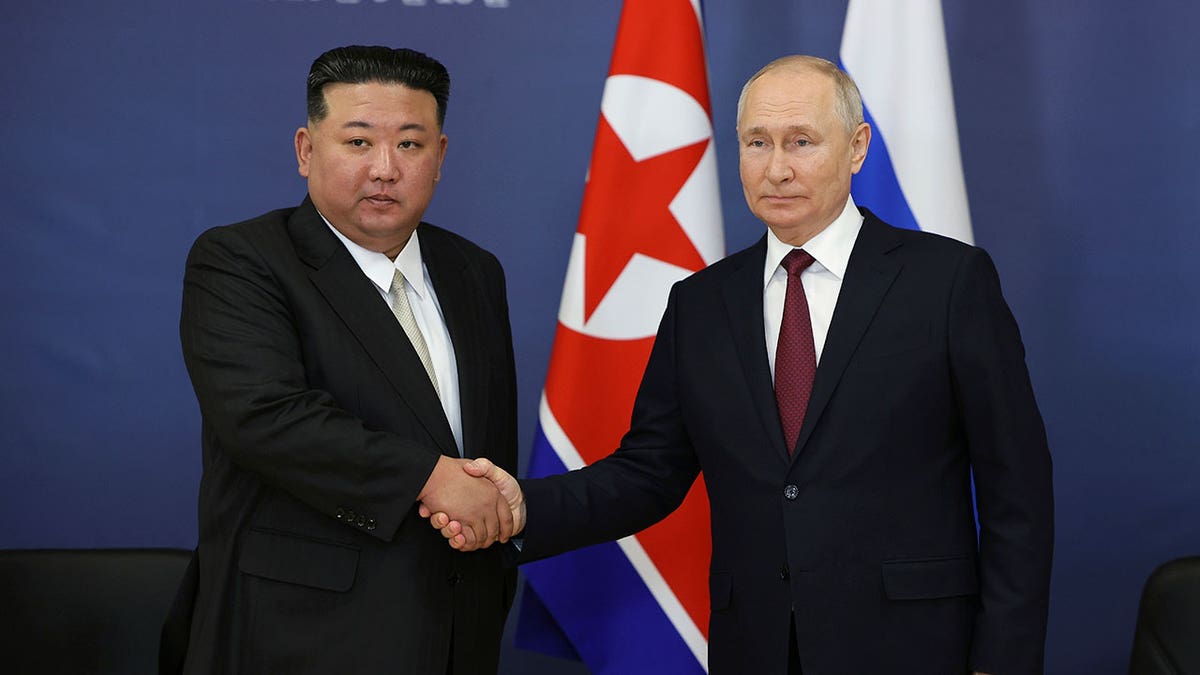 Russian President Vladimir Putin, right, and North Korean leader Kim Jong Un shake hands