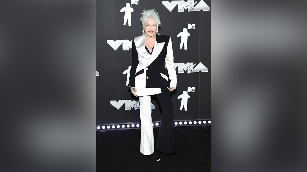 Cyndi Lauper at the 2024 MTV VMAs wearing a black and white suit.