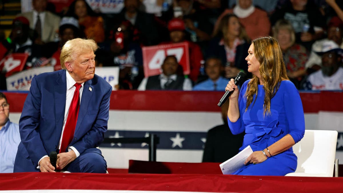 Former President Trump, left, with Gov. Sarah Huckabee Sanders, right