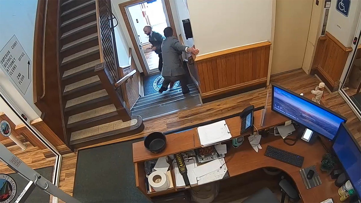 A plainclothes officer chases Nicholas Carter down a staircase