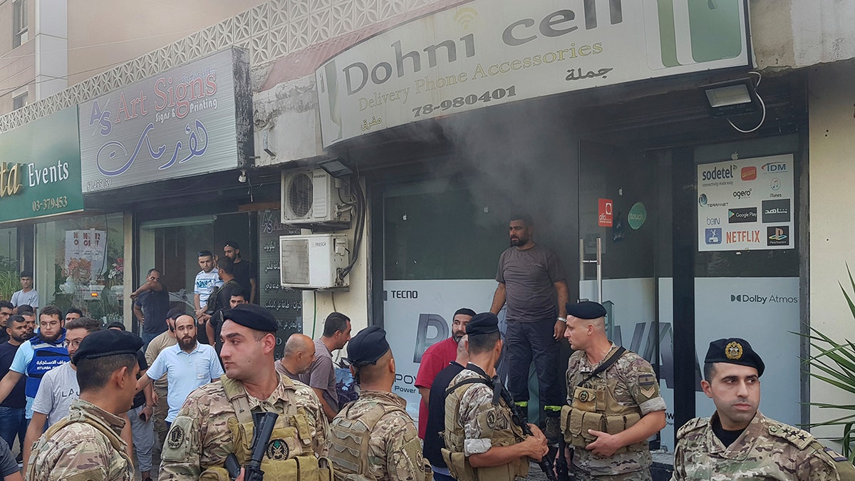 Lebanese soldiers outside damaged mobile shop