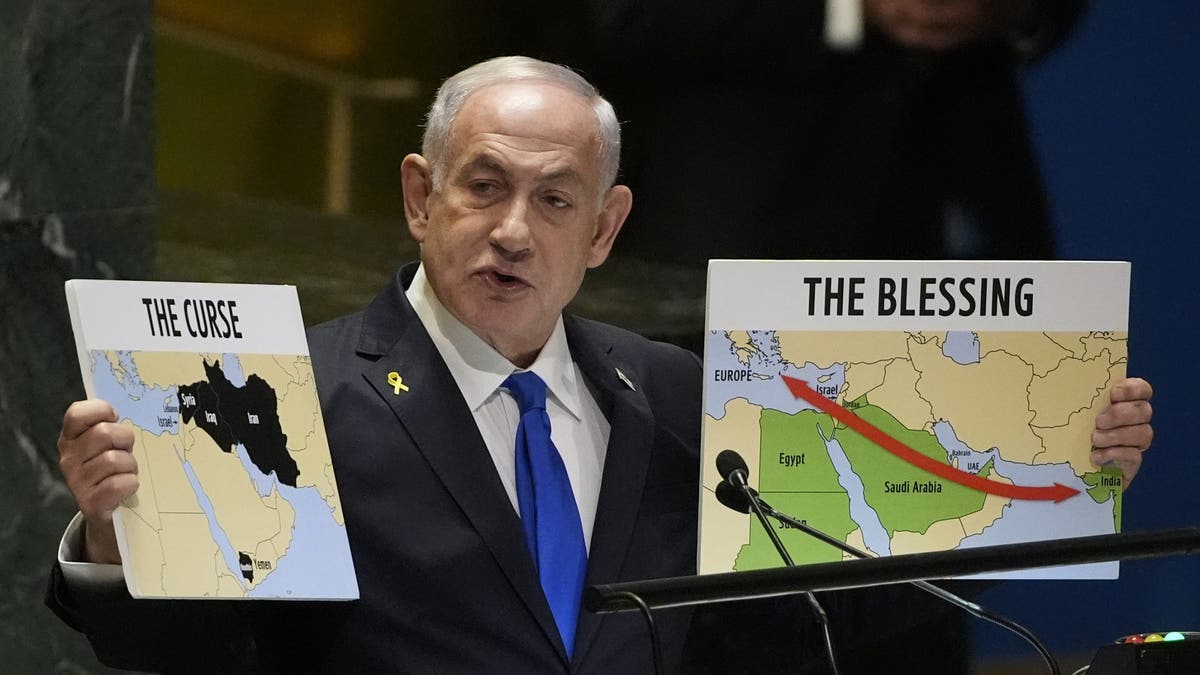 Prime Minister of Israel Benjamin Netanyahu holds signs as he addresses the 79th session of the United Nations General Assembly amid conflict with Hezbollah and Hamas.