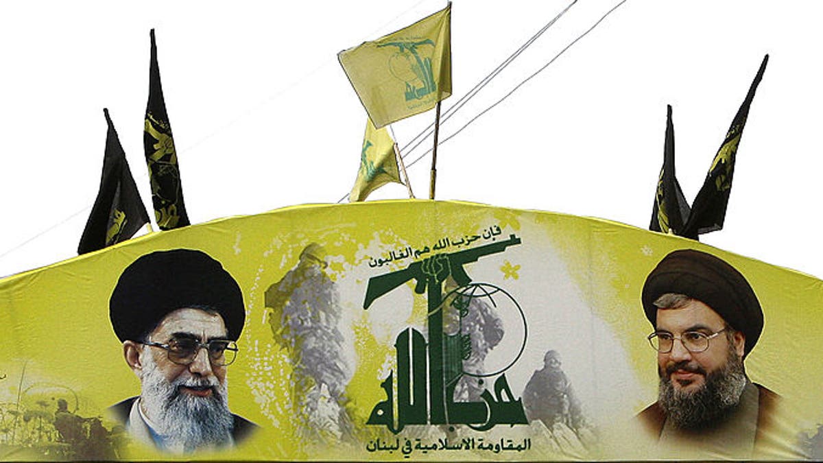 An arch glorifying Hezbollah and baring pictures of its chief Hassan Nasrallah, right, and Iran's spiritual leader Ali Khamenei decorates a street of Beirut's southern subburb on Jan. 16, 2011.