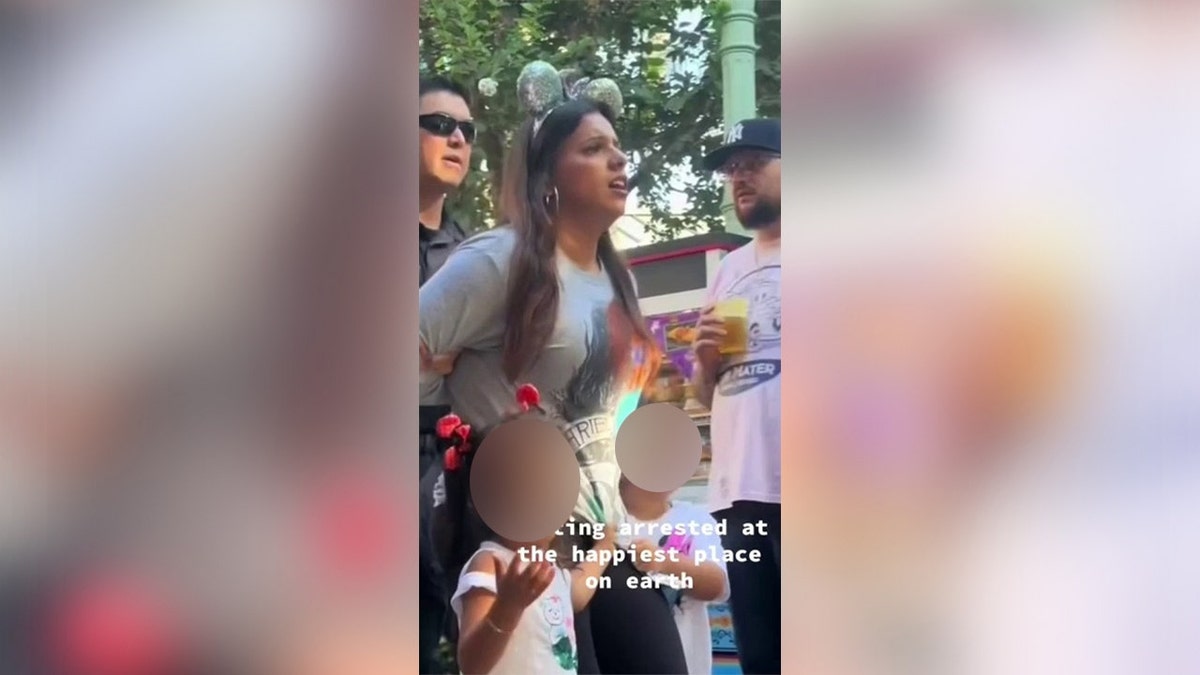 A woman is escorted by Anaheim Police after her arrest at Disneyland.