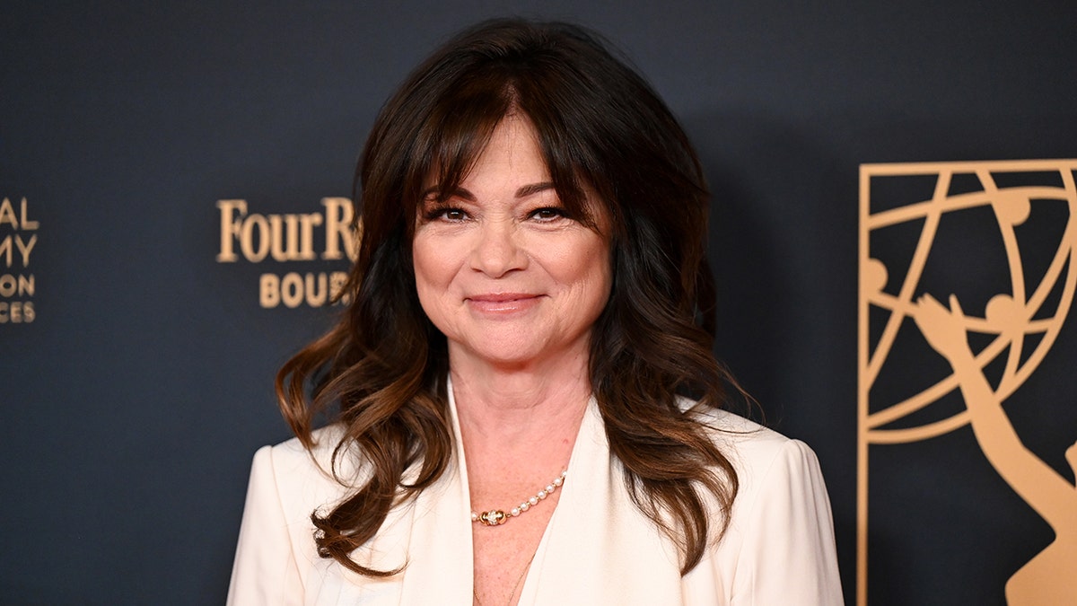 Valerie Bertinelli in a white blazer soft smiles on the carpet