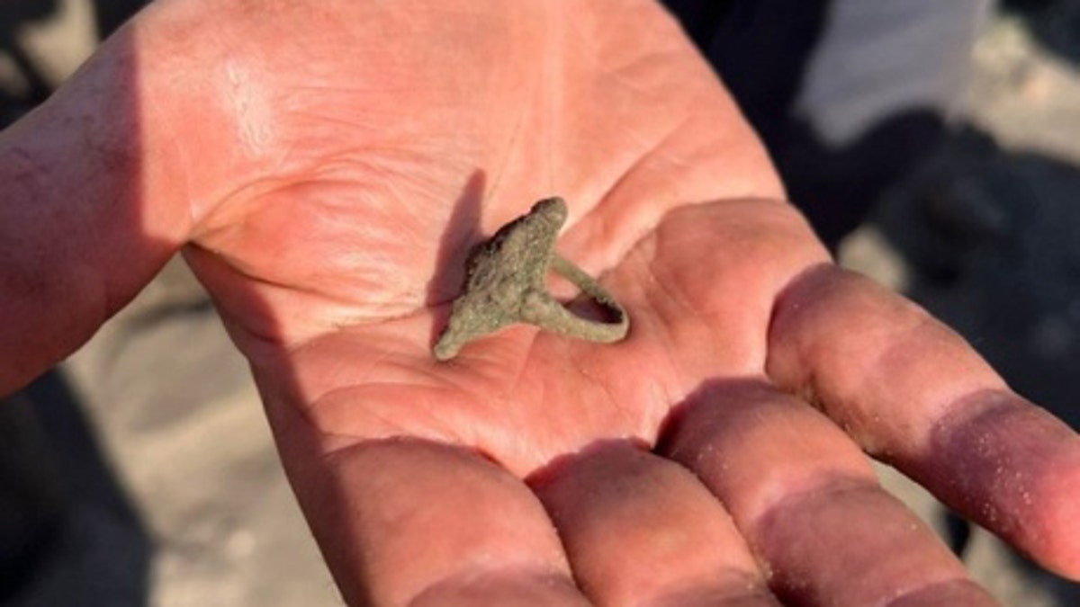 Finder holding the ancient ring he discovered