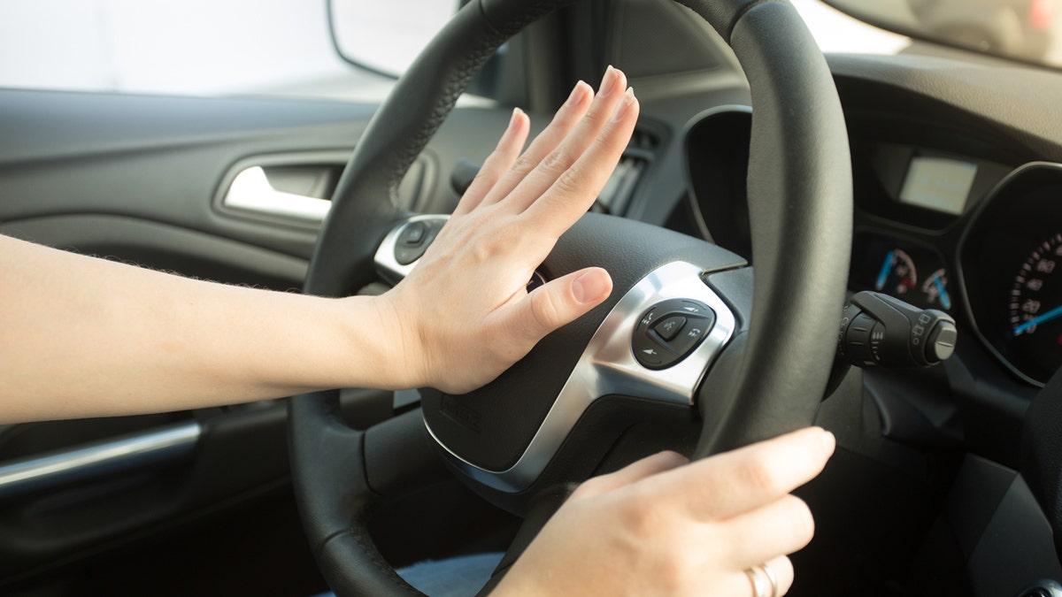 A person honking a car horn