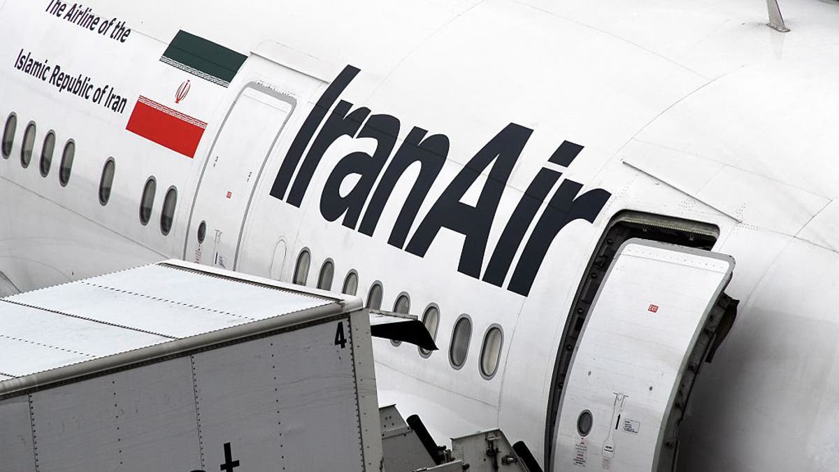 An Iran Air plane parked at an airport terminal in Europe.