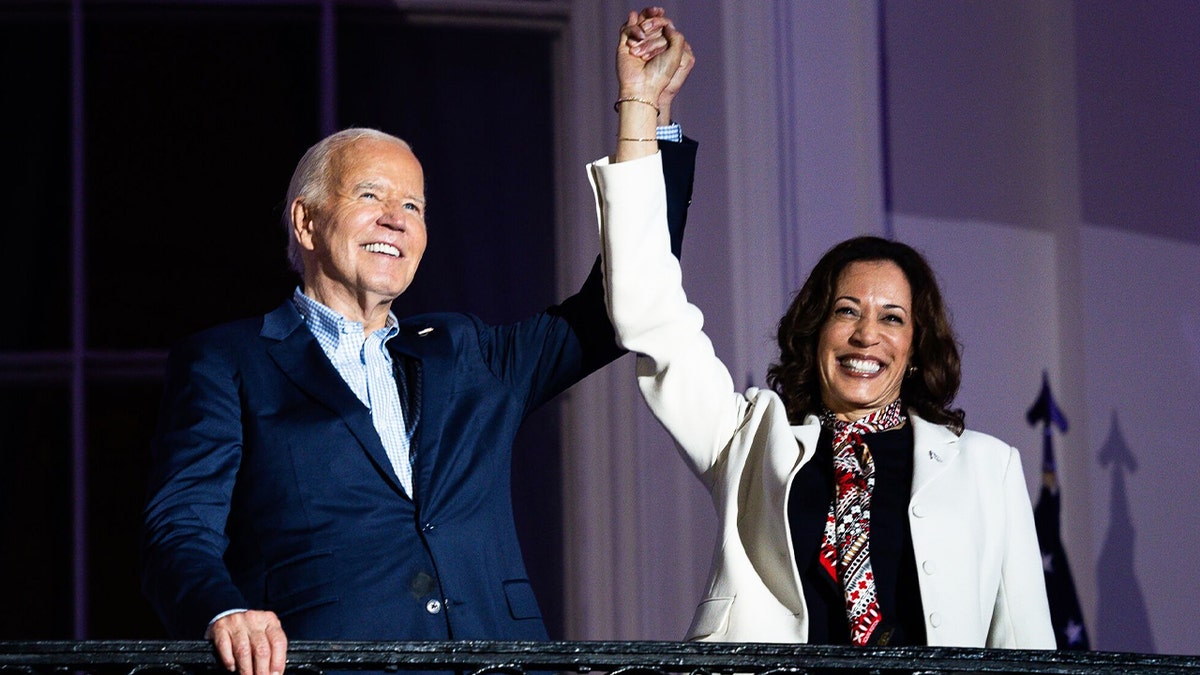 Biden and Harris on balcony, arms raised