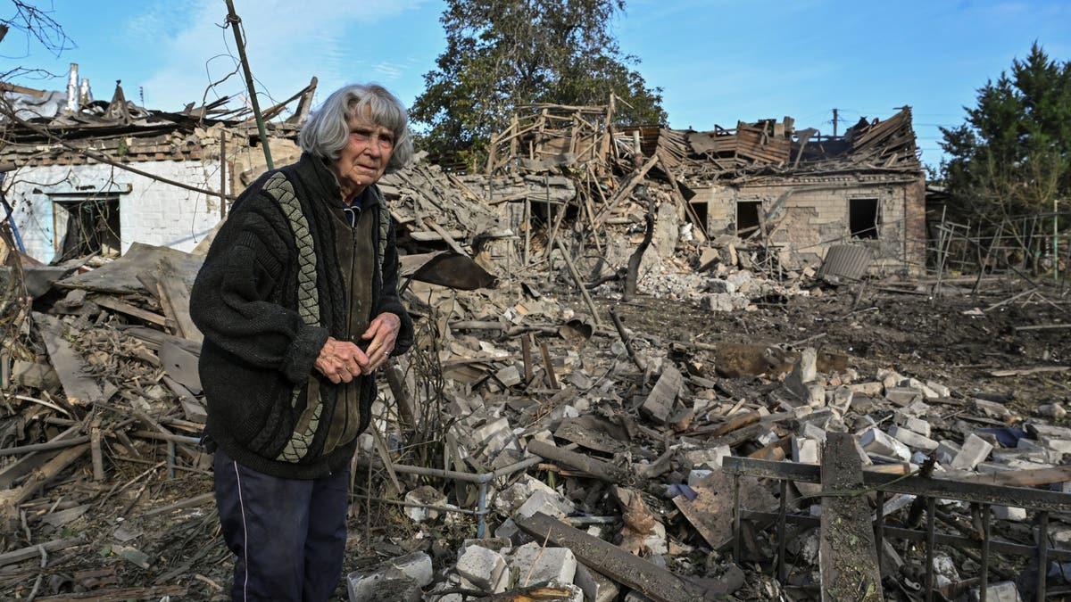 A woman stands in the backyard of her house destroyed by a Russian air strike, amid Russia's attack on Ukraine, in Zaporizhzhia, Ukraine, on Thursday. (Reuters/Stringer)