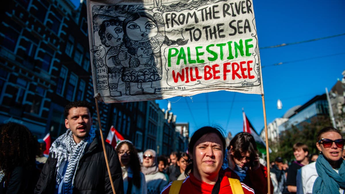 Anti-Israeli protester in Amsterdam, Netherlands holds up a poster with the slogan ‘From the River to the Sea, Palestine will be Free.’ The ADL has called the slogan antisemitic. Amsterdam, October 5, 2024.