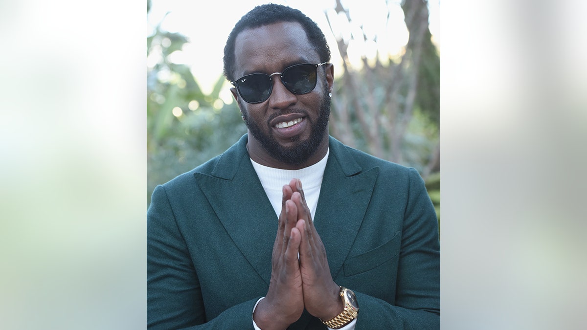 Diddy making prayer hands to camera