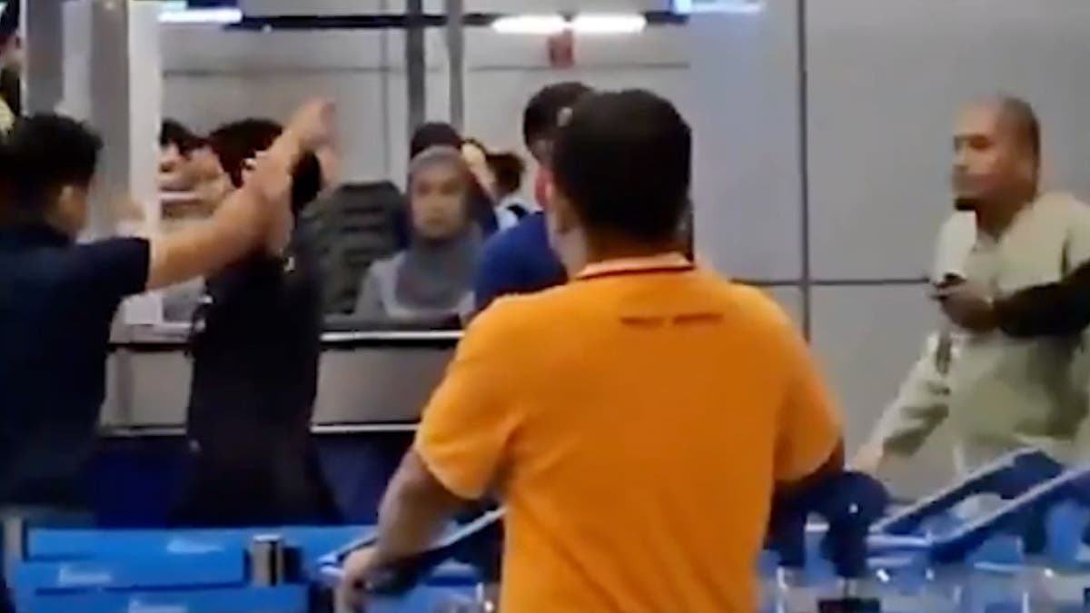 An airline worker and passenger arguing