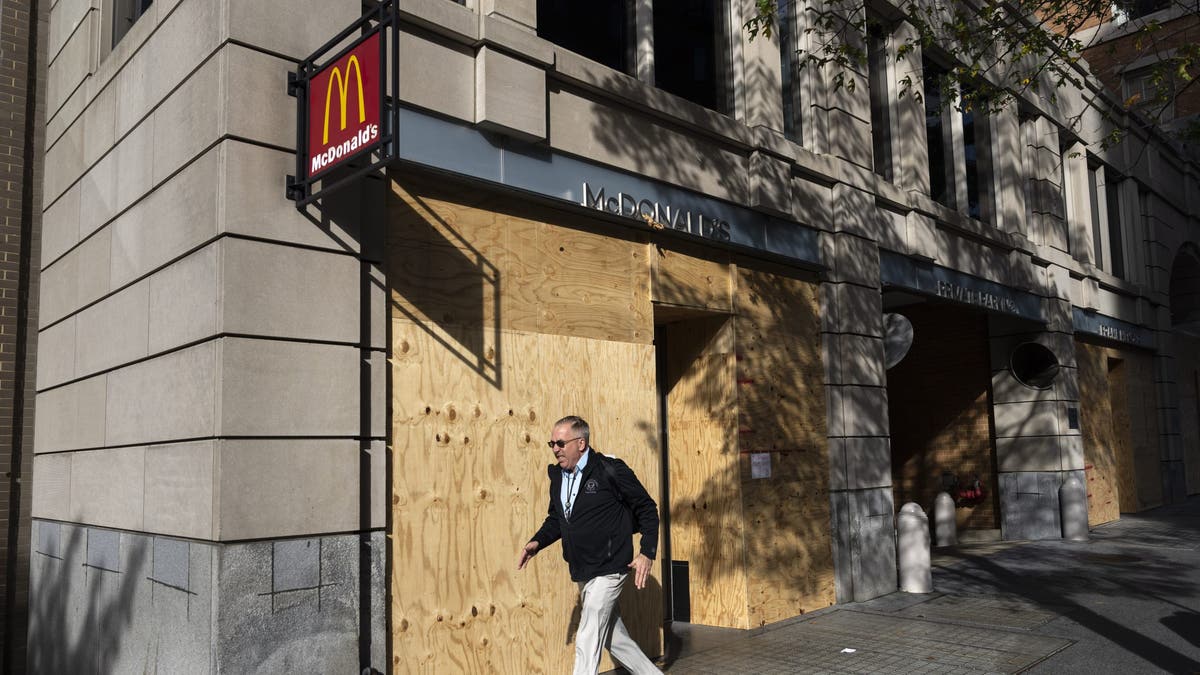 man walks by boarded up McDonald's in Washington, D.C. 