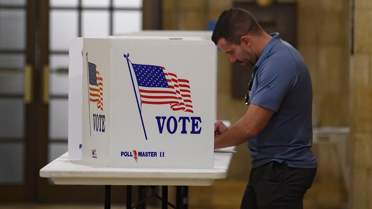 man voting at voting carrel