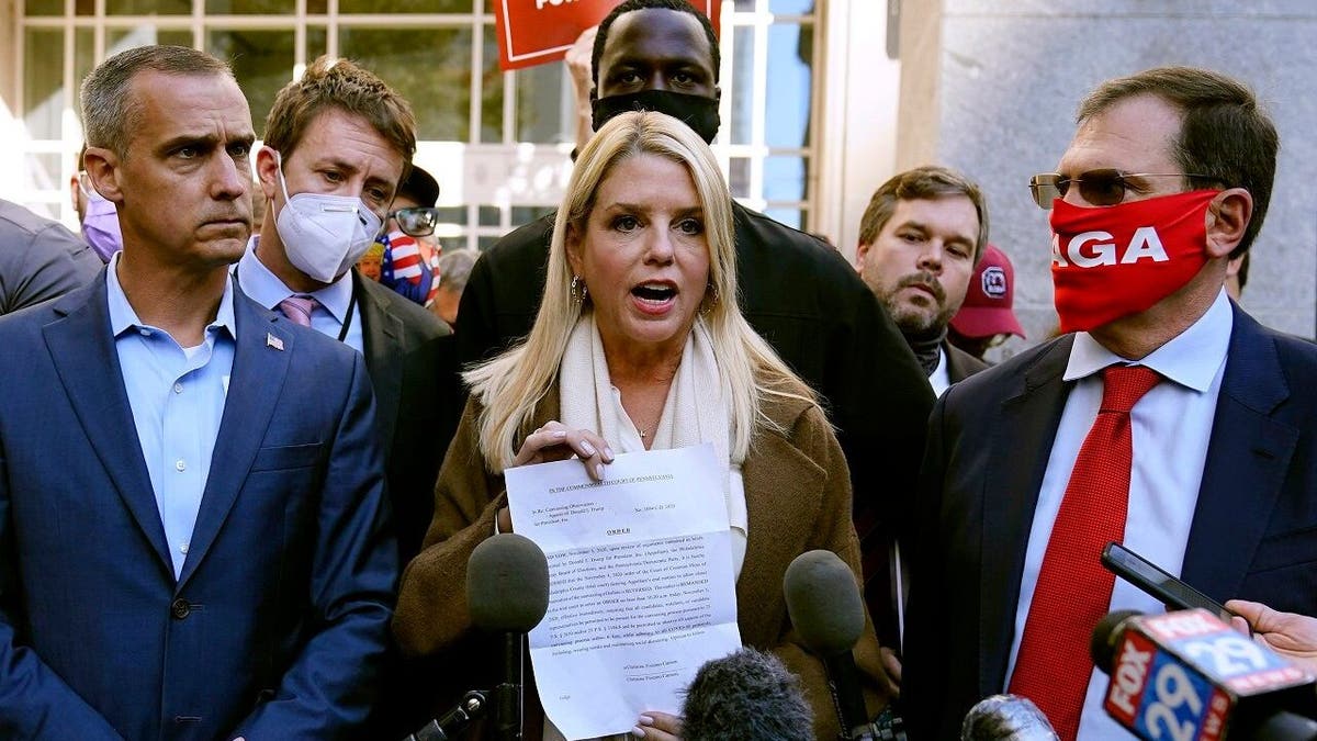 Former Florida Attorney General Pam Bondi displays a court order granting Trump's campaign more access to vote counting operations at the Pennsylvania Convention Center, Nov. 5, 2020, in Philadelphia. (AP Photo/Matt Slocum)