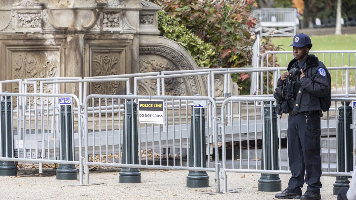 Capitol police officer stands near security fencing before Election Day 