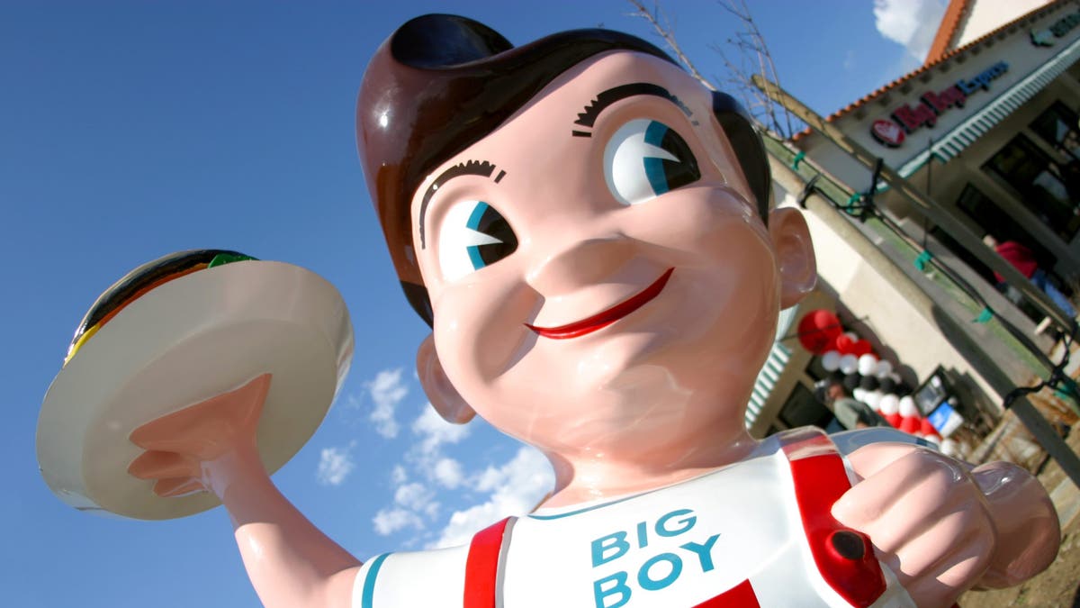 Big Boy statue smiles and holds a burger on a plate