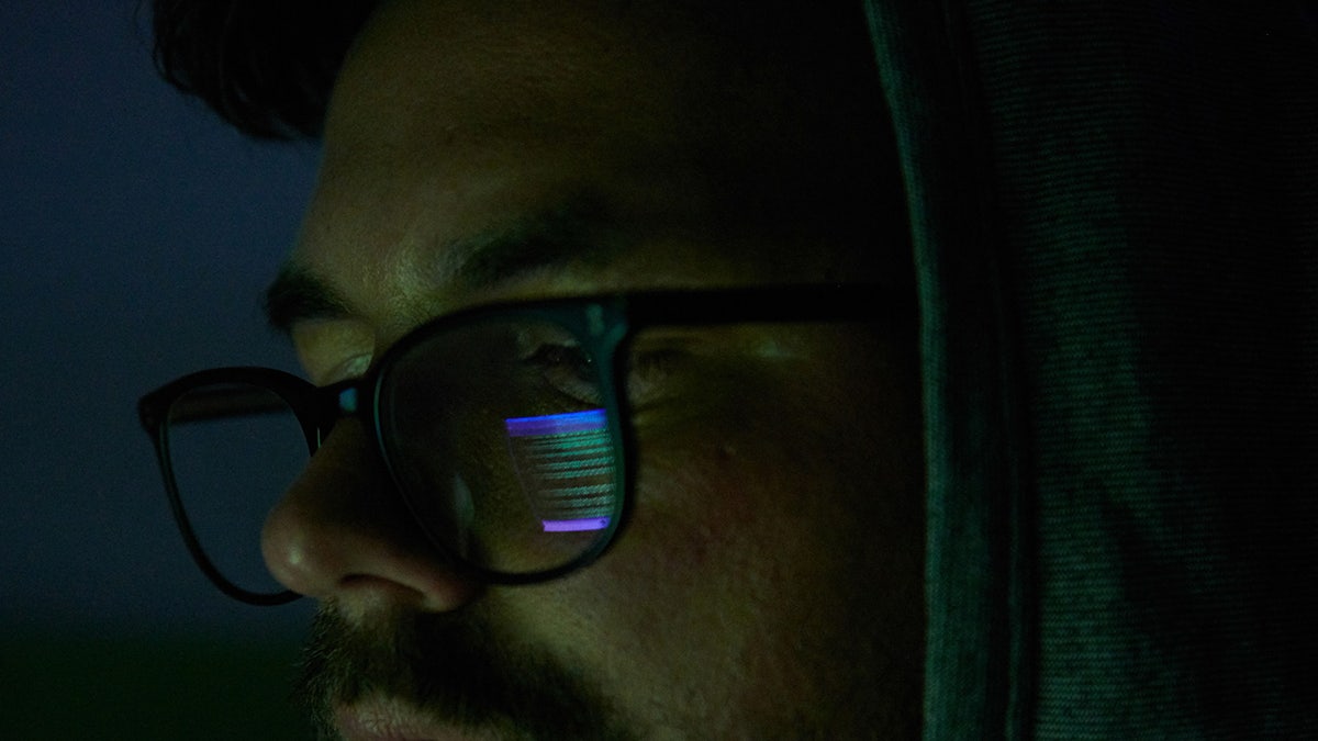 A close-up of someone with glasses looking at a screen.