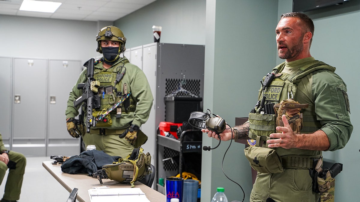 Police in uniform preparing to execute a search warrant.