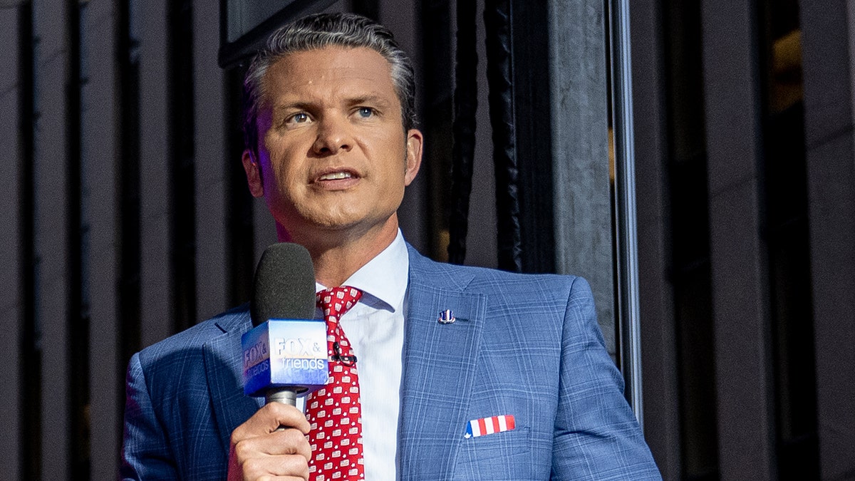 Pete Hegseth holding a microphone