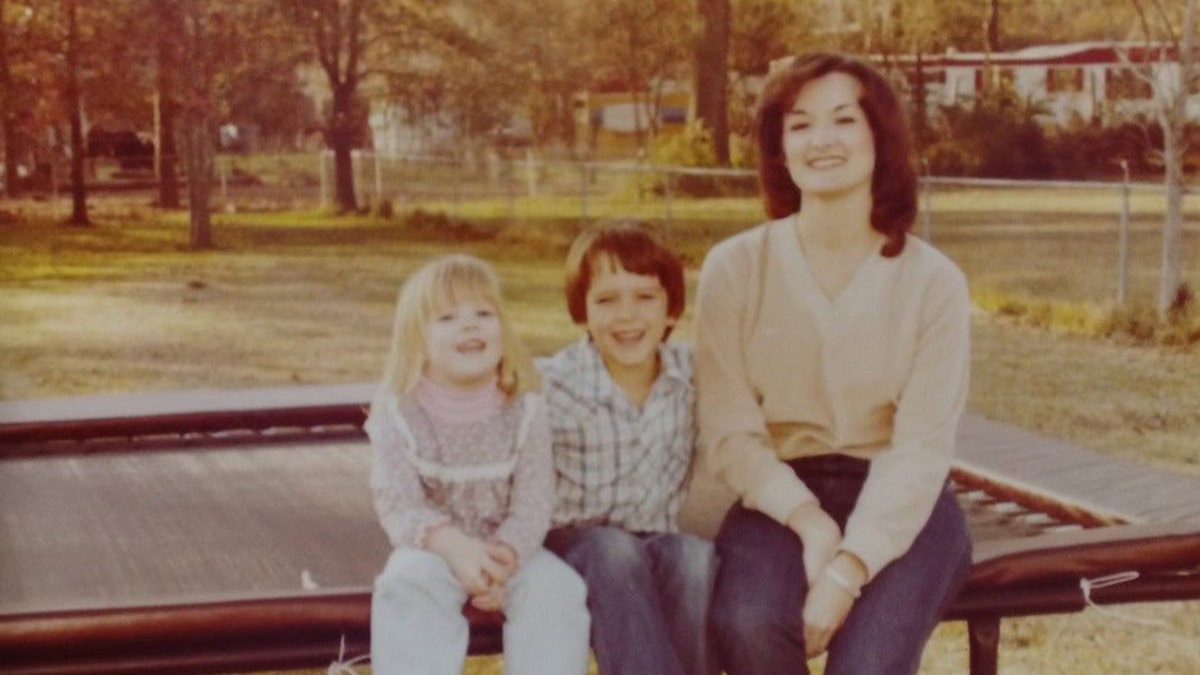 Wanda Holloway smiling and posing with her two children.