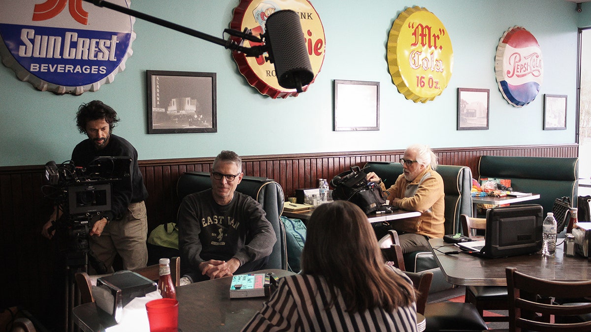 A film crew recording a scene in a restaurant.