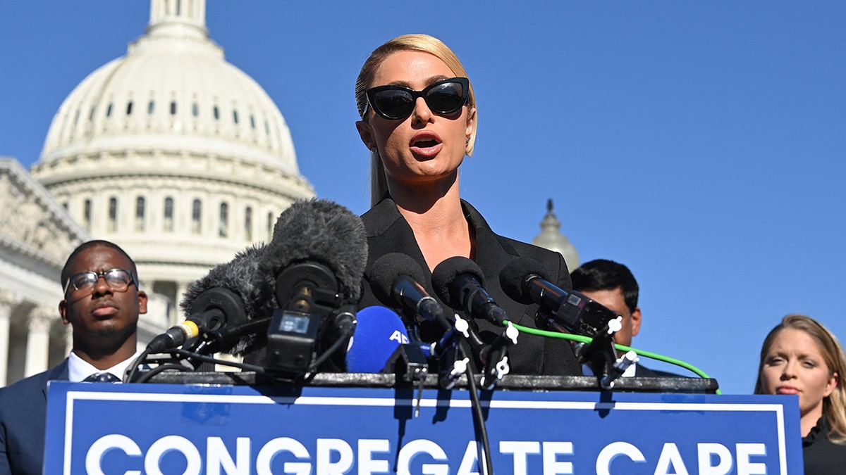 Paris Hilton speaking with Capitol dome behind her