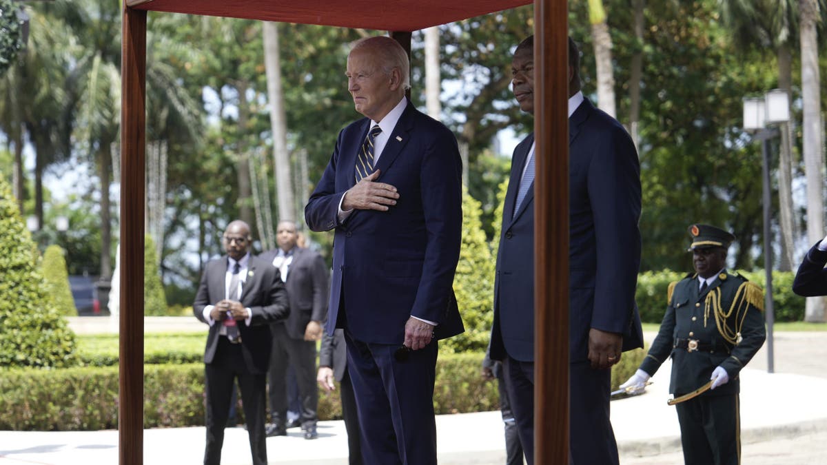 President Biden, left, stands for national anthems with Angolan President Joao Lourenco at the presidential palace in Luanda, Angola on Tuesday, Dec. 3, 2024.