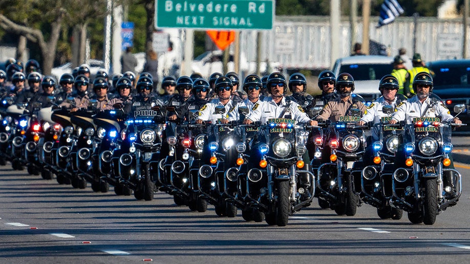 Law enforcement officers ride their motorcycles south along State Road 7 during a procession for three Palm Beach County Sheriff's Office deputies who died last month