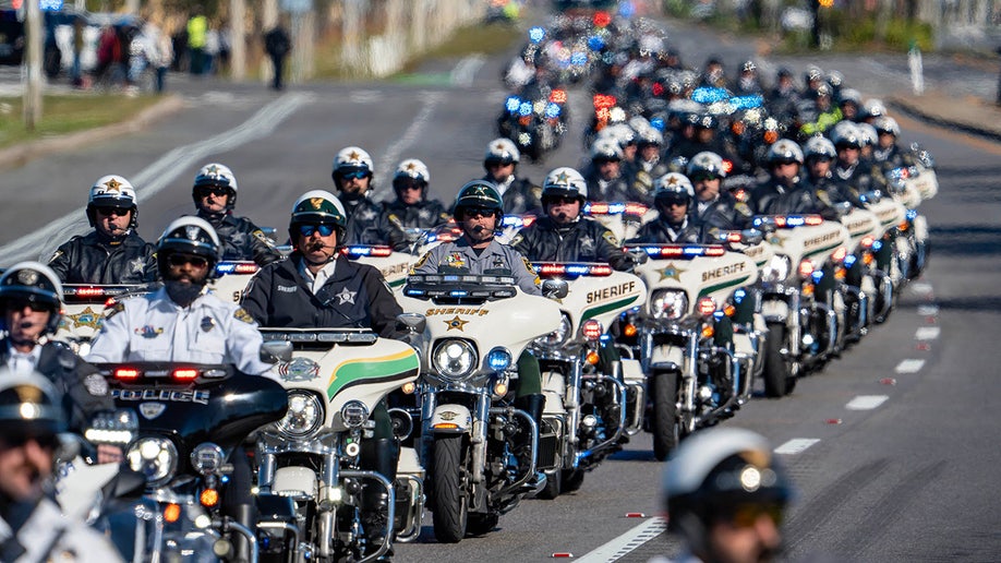 Law enforcement officers ride their motorcycles south along State Road 7 during a procession for three Palm Beach County Sheriff's Office deputies who died last month